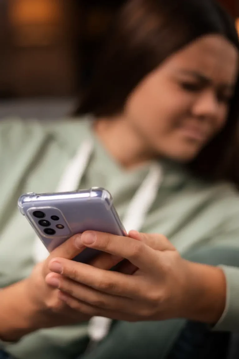 Meisje met sociale media verslaving kijkt weg door afkeer van haar smartphone.